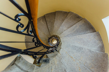 Old spiral metal staircase inside tower, bottom view