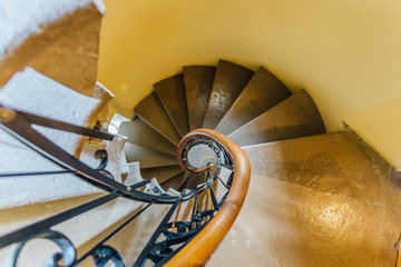 Old spiral metal staircase inside tower, upside view