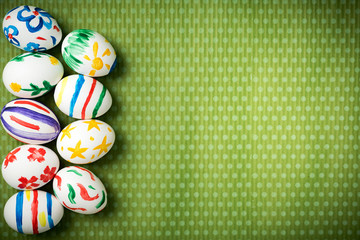 Easter eggs painted by hand on a beautiful green background in white peas. Festive background. Easter ideas. Space for text. Happy easter.