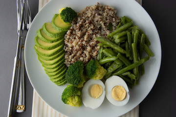 Salad bowl with quinoa and green vegetables - green peas, avocado, broccoli and eggs. Healthy food, green salad palte.