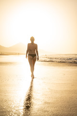 Piękna kobieta idąca plażą- wakacje - obrazy, fototapety, plakaty
