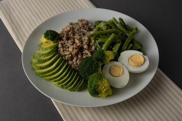 Salad bowl with quinoa and green vegetables - green peas, avocado, broccoli and eggs. Healthy food, green salad palte.