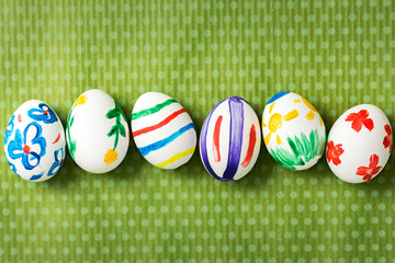 Easter eggs painted by hand on a beautiful green background in white peas. Festive background. Easter ideas. Space for text. Happy easter.