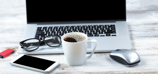 Cup of coffee with workstation technology in background
