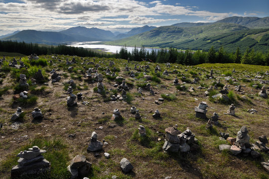 Stone cairns on Highway A87 at Loch Loyne with Spidean Mialach on left and Creag a' Mhaim Highland mountains on right Scotland