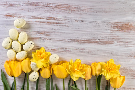 Retro tradition easter background with yellow flowers and easter eggs. Top view, text space