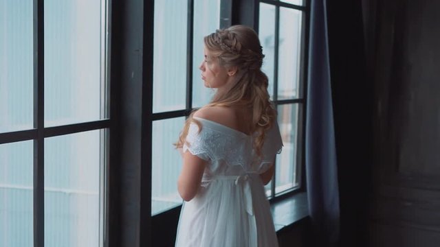 gentle touching image of an untouched girl, sweetie sharpened in an old medieval castle with large windows, new image of Cinderella in long white dress with large lace, lady with healthy blond hair