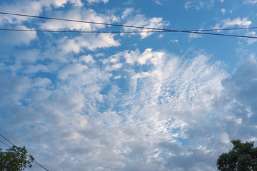 blue sky with white clouds and telephone wires