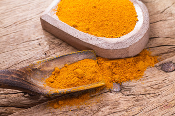 Turmeric powder on wooden background