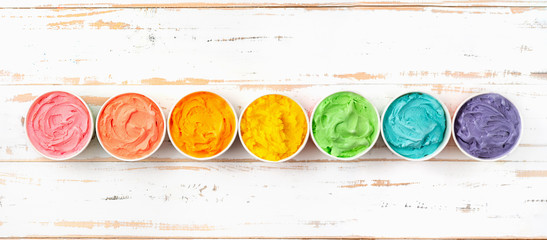 Many cups with colorful rainbow ice cream. Top view