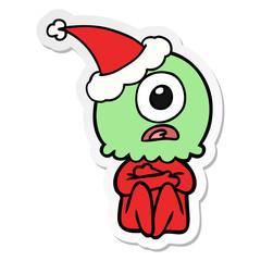 sticker cartoon of a cyclops alien spaceman wearing santa hat
