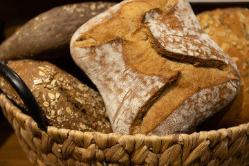 Homemade breads cooked in wood-fired oven as formerly yummy. Delicious large breads packed with flour in a basket