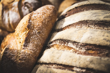 Homemade breads cooked in wood-fired oven as formerly yummy. Delicious large breads packed with flour in a basket