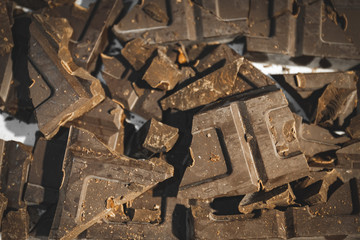 Broken bar chocolates destroyed and accumulated. Delicious chocolates about to be melted