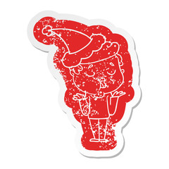 cartoon distressed sticker of a man talking and shrugging shoulders wearing santa hat