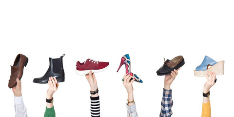 Hands holding different shoes on isolated background
