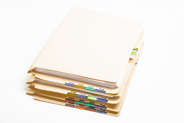 A stack of color-coded and numbered yellow file folders containing sheets of papers, files and documents set on a white background.