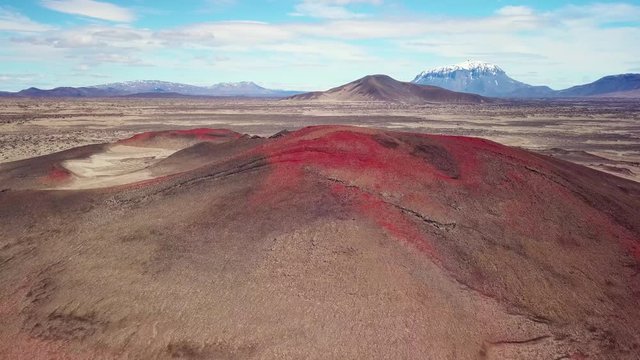 Spectacular aerial over red ash topped volcanoes and lava flows in the remote highland interior of Iceland.