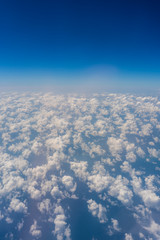 Fototapeta premium White clouds and blue sky, a view from airplane window