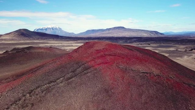 Spectacular aerial over red ash topped volcanoes and lava flows in the remote highland interior of Iceland.