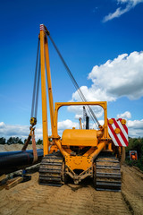 Gaspipeline - Anheben der Stahlrohre durch einen Bagger mit Auslegerarm