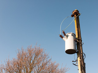 metal bucket hanging on pole electrics outside wires