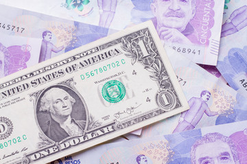 dollar bill over Colombian pesos