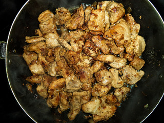 fried meat with onions in a frying pan