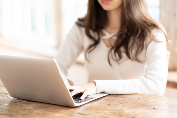 Naklejka premium attractive asian woman using laptop in living room