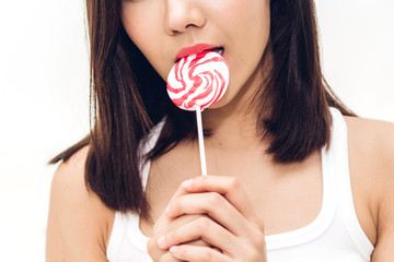 Portrait of sexy women holding and lick big pink lollypop
