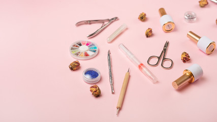A set of cosmetic tools for manicure and pedicure on a pink background. Gel polishes, nail files and nippers and top view. Composition for a card with a place for the text, Flat-lay