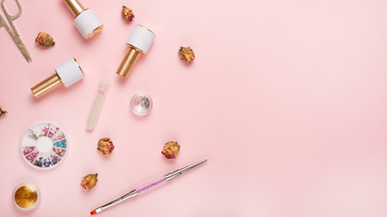 A set of cosmetic tools for manicure and pedicure on a pink background. Gel polishes, nail files and nippers and top view. Composition for a card with a place for the text, Flat-lay
