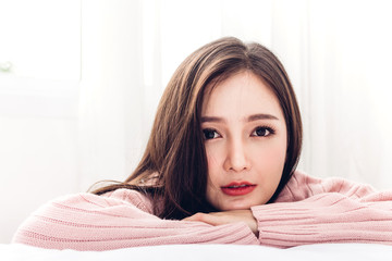 Naklejka premium Portrait of happy smile asia woman enjoy and relax on the bed in bedroom at home.asian beauty