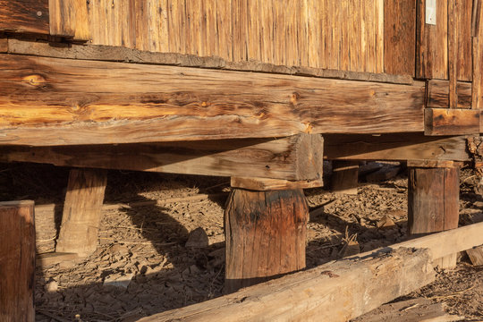 Construction detail of wood piers and beams supporting an old building, American Southwest, horizontal aspect