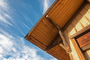 Old building with exterior corner roof detail, blue sky, construction detail, horizontal aspect