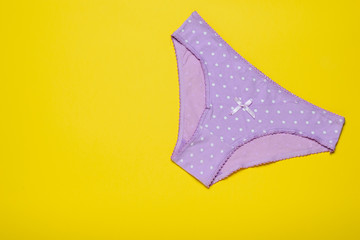 Lilac women's panties on a bright yellow background. Fashionable concept. Beautiful lingerie. The view from the top.
