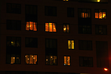 Naklejka premium Glowing apartment windows at night where each occupant has his own privacy
