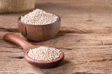 Quinoa seeds in bowl on rustic wood