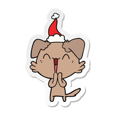 laughing little dog sticker cartoon of a wearing santa hat