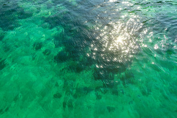 Fototapeta na wymiar Surface of clear transparent turquoise seawater with small waves