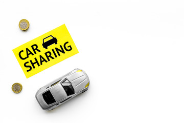 Carsharing concept, carsharing sign. Economical, chip trip. Toy car near coins on white background top view copy space