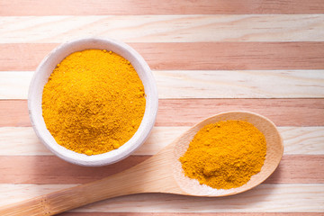 Turmeric powder on wooden background
