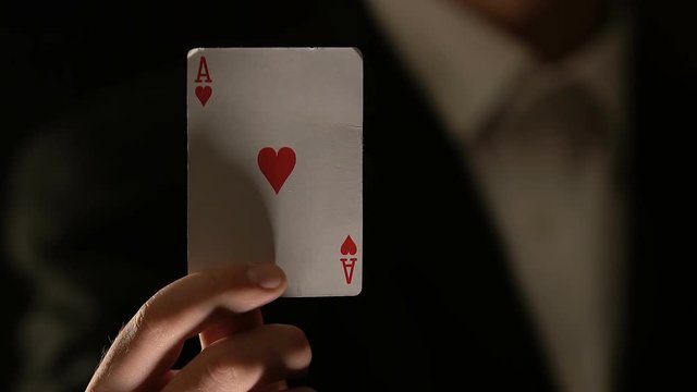 Male showing ace of hearts into camera, fortune sign, poker game winning