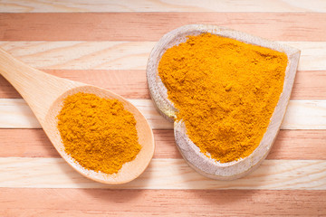 Turmeric powder on wooden background