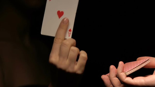Man proposing woman to choose card from deck, lady showing ace of hearts