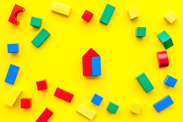 Fototapeta na wymiar Children background. Wooden building blocks for developing and entertainment on yellow background top view