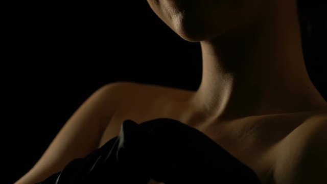 Seductive woman in black gloves stroking her naked decollete zone, flirting
