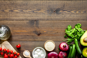 Fresh organic vegetables on dark wooden background top view space for text. Kitchen desk for preparing salad