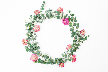Floral frame with pink roses flowers and eucalyptus branch on white background. Flat lay, top view