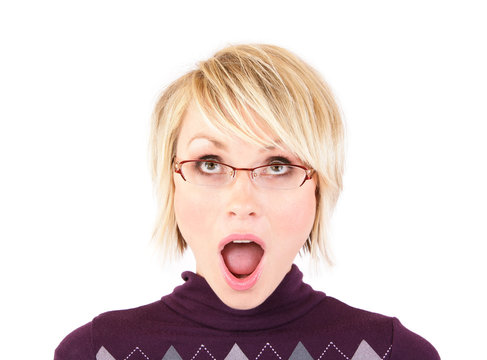 A woman in her 30's with short blonde hair wearing glasses is looking up with a surprised look on her face.